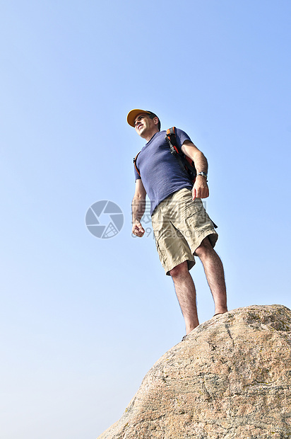 在岩石上站立的希克人远足冒险首脑成人登山者背包蓝色娱乐成就远足者图片