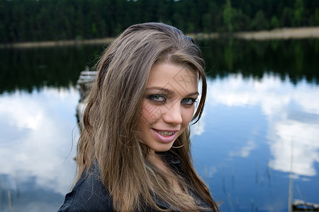 年轻性女孩的肖像蓝色木头女士天空绿色反射成人图片