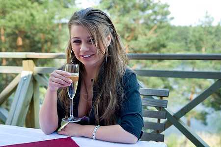 年轻女孩 拿着香槟杯子咖啡店玻璃嘶嘶声绿色阳台讲台门廊高脚杯图片