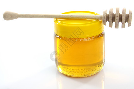 蜜罐上的木制蜂蜜干燥器蜂窝液体玻璃生产木头金子细雨产品食物营养图片