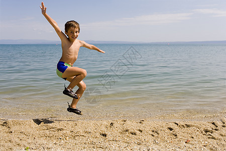 儿童在海滩上跳跃海景热带人民海岸天空海洋图片
