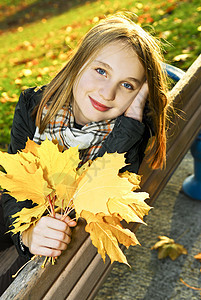秋天的少女晴天微笑孩子们女性公园树叶叶子地面橙子幸福图片