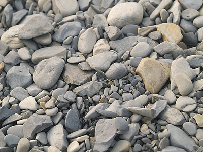 平滑的河石纹理椭圆形卵石砂岩海岸线石头宏观材料矿物质岩石背景图片