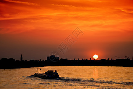 日落时用货物与货舱对接运输橙子城市太阳船运货运天际全景天空景观图片
