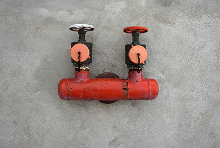 水泥墙上的红铁阀门水管龙头供水管道气体设施分发螺栓公用事业红色图片