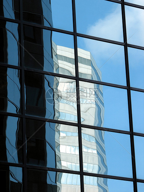 公司塔楼 反映另一座办公大楼和天空图片