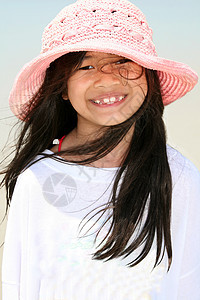 海滩上可爱的小女孩喜悦女孩海洋泳装粉色牙齿享受海滨蓝色混血图片