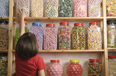 儿童在糖果店青年选择集装箱孩子顶架店铺少年罐子货架童年图片
