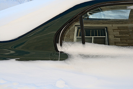汽车在深雪中反射着周围建筑物图片