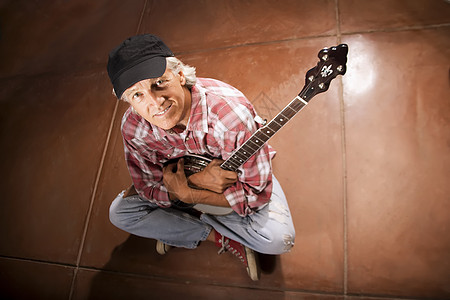 Banjo 玩家坐在水泥板上图片