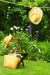 挂在衣着线上的草帽稻草椅子绿色太阳帽衣绳花园洗衣帽子钱包衣服图片