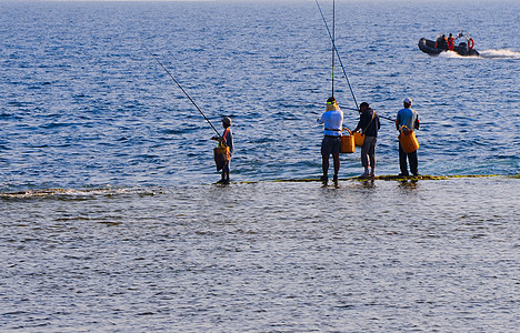 渔民海岸线闲暇海岸钓鱼刀具男人支撑乐趣海滩波纹图片