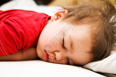 穿红衣服男孩穿红衣服的男孩睡在床上生活男孩们和平就寝睡眠儿子安全时间家庭午睡背景