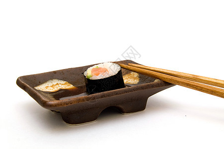 鲑鱼卷盘上放着鳄梨和筷子餐厅优雅寿司吃饭美食文化白色海藻小吃服务图片