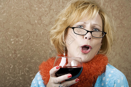 有趣的妇女饮酒酒红色酒精黄铜色嘴唇眼镜狂欢饮料豪饮眼睛鸡肋图片