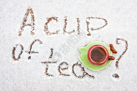 雪地背景上一杯茶飞碟黑色背景图片