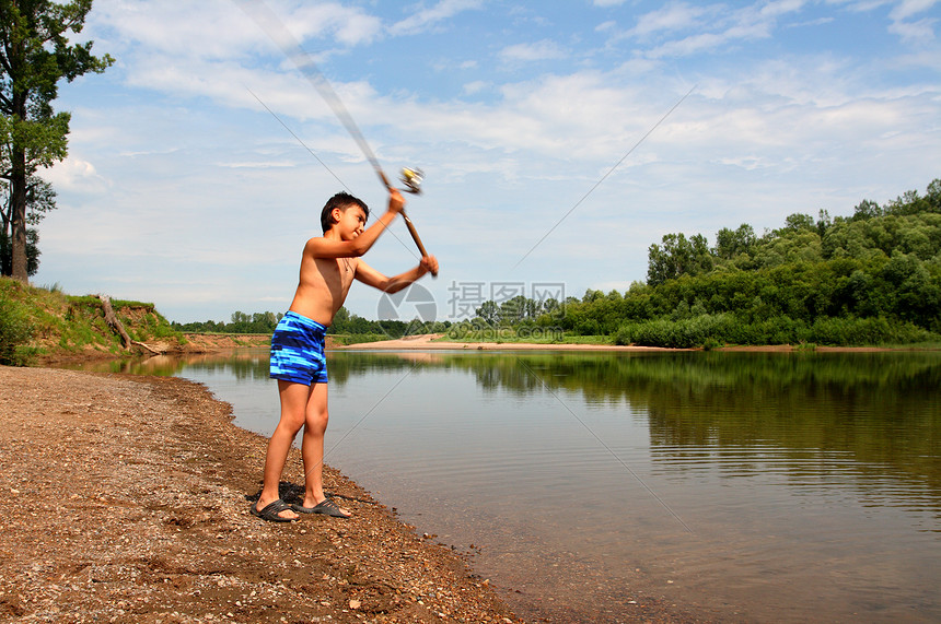 男孩通过旋转钓鱼乐趣铸件活动纺纱场景蓝色行动卷轴海滩渔夫图片