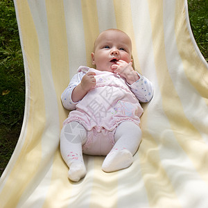 吊床上的婴儿黄色孩子女儿女性阳光粉色童年后代儿童花园图片