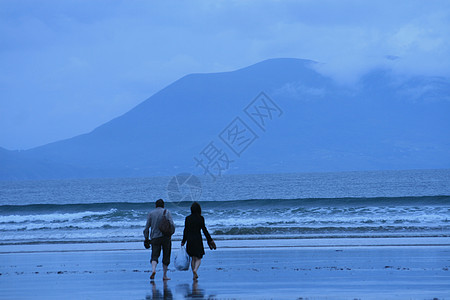 在雨中行走的情侣蓝色海岸山脉海滩图片