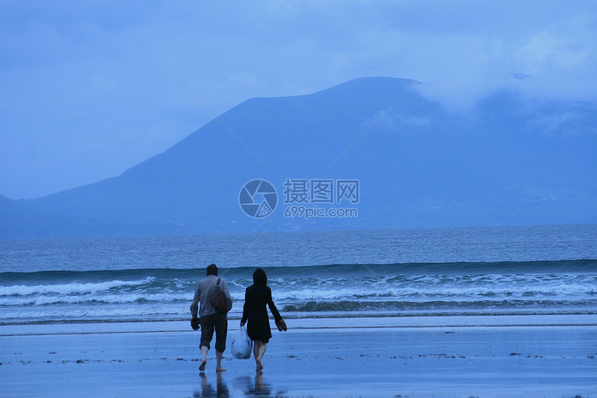 在雨中行走的情侣蓝色海岸山脉海滩图片