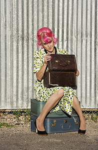 有粉色头发和小饼干盒的女人月下街道化妆品褶皱时尚旅行胡同手提箱女性逃学图片