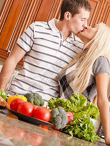 在厨房的年轻夫妇亲吻图片
