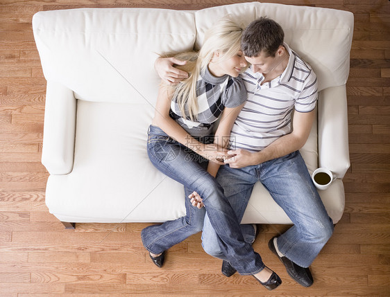 年轻夫妇坐在爱情座位上感情男人夫妻硬木微笑地板压板幸福团结沙发图片