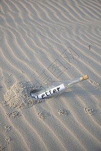 在沙中装瓶子脆弱性海浪纹理热带场景日落孤独玻璃气候假期图片