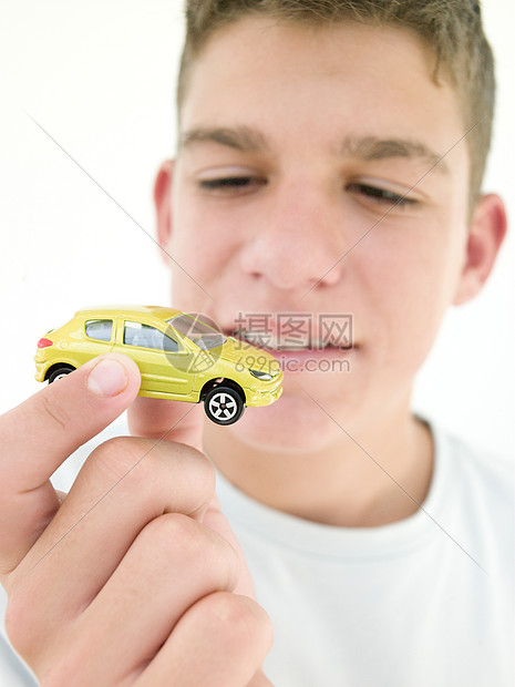 年轻男孩拿着玩具车微笑孩子们学车司机男生影棚男性享受爆头开车情感图片