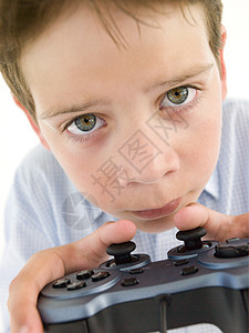 使用视频游戏控制器和集中力的年轻男孩图片