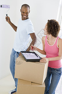 伴着滚滚和涂彩 在新家微笑女性两个人搬运箱男人盒子绘画抵押画家房子享受图片