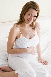 坐在床上笑着的孕妇卧室肚子医疗孕产女性待产新妈妈孕妇装妈妈女子图片