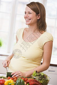 厨房的孕妇在笑着做沙拉待产家庭孕妇装准妈妈妈妈饮食怀孕食物蔬菜女性图片