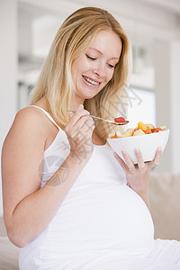 带一碗水果沙拉微笑的孕妇家庭孕产怀孕食物早餐妈妈饮食小吃家长女性图片