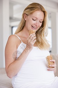 孕妇吃着面包 笑着微笑怀孕饮食新妈妈女性妈妈家长孕产享受准妈妈待产图片