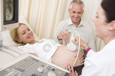孕妇从有丈夫手表的医生那里得到超声波检查考试检查女士男人女性准妈妈扫描孕妇装怀孕卫生图片