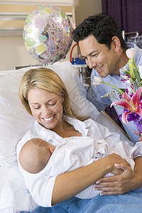 新母亲带着婴儿和丈夫在医院中微笑的笑容女孩新妈妈三个人女儿拥抱孕妇装女士访问妈妈新生儿图片