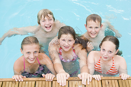 五个在游泳池里微笑的年轻朋友孩子友谊相机乐趣五个人游泳男性男生队友女朋友图片