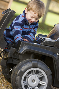 躺在地上男孩年轻男孩在户外玩耍 带着玩具卡车微笑背景