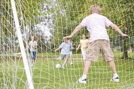 五个年轻朋友在踢足球花园五个人闺蜜游戏小男孩玩家男生女孩童年足球图片