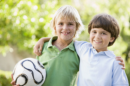 两个男孩在户外 带着足球微笑的足球球图片