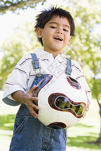 在户外微笑着拿着足球球的年轻男孩公园女性享受男性游戏小男孩拉丁花园童年孩子图片