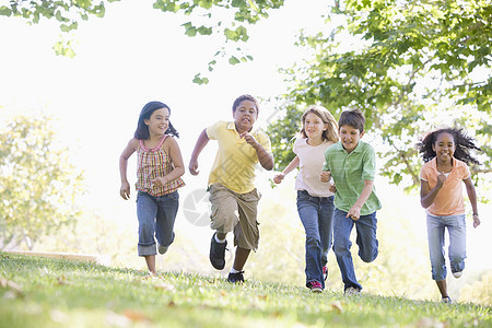 五个年轻朋友在户外笑着跑享受朋友们乐趣小男孩公园跑步童年女孩友谊男性图片