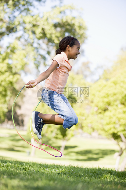 年轻女孩在户外笑着跳过绳子跳跃微笑跳绳享受乐趣健康女性孩子农村图片