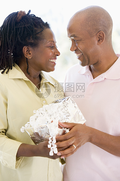 丈夫和妻子带着微笑着的礼物的丈夫和妻子生日男人中年情感浪漫女士惊喜两个人亲热男性图片