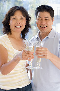 一起为香槟敬酒和微笑妻子男人情感亲热伙伴花束礼物场合女性中年图片