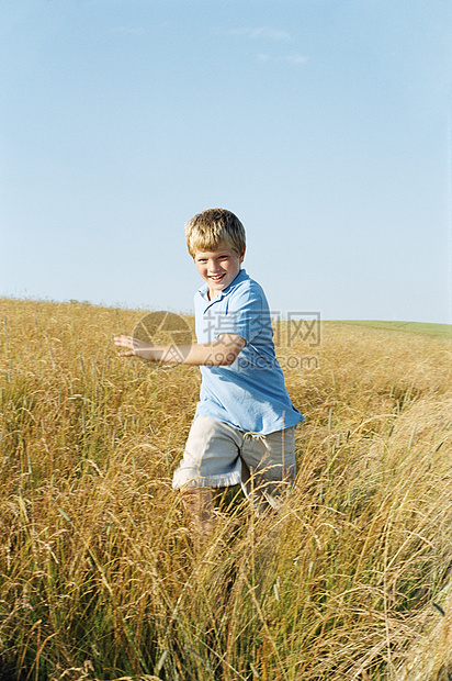 年轻男孩在户外流笑自由小男孩活力场地相机农村精力微笑跑步男性图片
