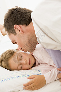 醒来的年轻女孩与亲吻在床上图片