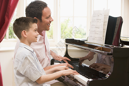 男人和小男孩弹钢琴 微笑客厅儿子键盘钢琴家庭学习音乐男生男性家长图片