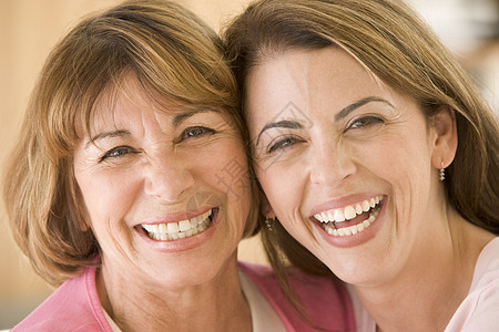 两个在客厅的妇女微笑着笑着沙发家庭生活妈妈水平休息室女性头肩相机拉丁成年图片
